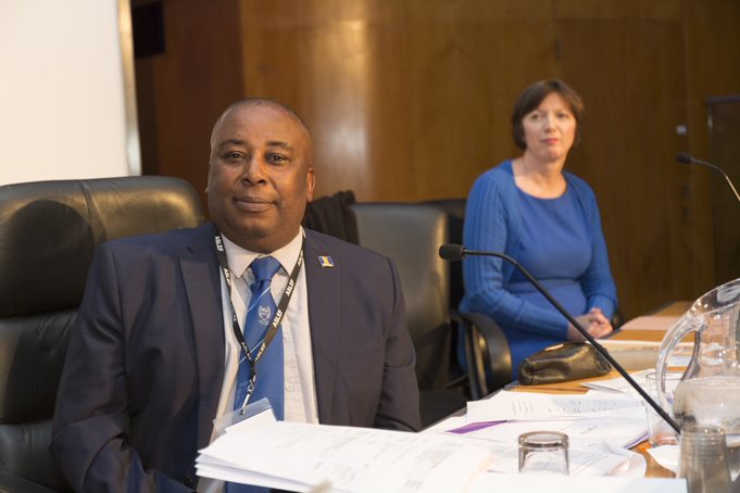 Floyd Doyle sits at a table next to Frances O'Grady. There are microphones in front of them.